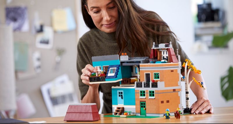 LEGO Creator Expert Bookshop modular - woman removing townhouse roof to look in side
